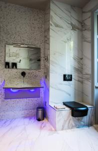 bagno con lavandino viola e specchio di Villa delle Fiabe - Homelike Villas a Ossuccio