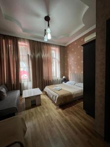 a bedroom with a bed and a couch at Hotel Albatros in Batumi