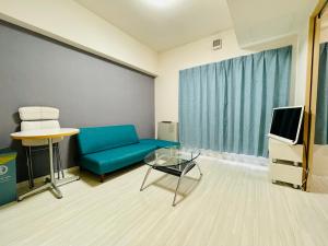 a living room with a blue couch and a tv at 2-2札幌駅徒歩7分の好立地Service Apartment SAPPORO札幌ステーション綺麗な部屋 in Kita-rokujō