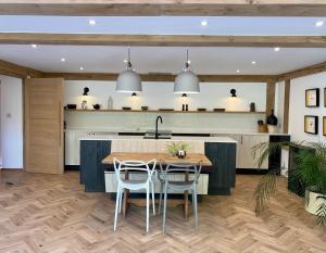 a kitchen with a table and some chairs and a counter at Weavers Rest in Biddenden