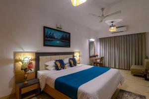 1 dormitorio con 1 cama grande con sábanas azules y blancas en Lotus & Orchid Villas by Ramnath Homes, en Sangolda