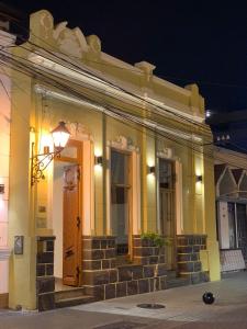 a yellow building with a door and stairs at night at Hotel Residencial España in Salta