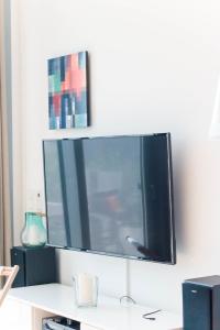 einen Flachbild-TV, der an einer Wand hängt in der Unterkunft Ostsee - Reetdachhaus Nr 2 "SÜDSTRANDHUS" im Strand Resort in Heiligenhafen