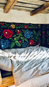 a bed with a blanket with flowers on it at Casa din deal in Baia-Sprie