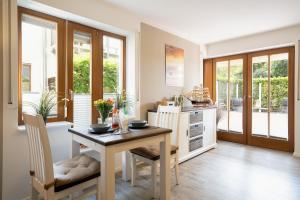 a dining room with a table and chairs and a kitchen at Premium Quartier Solymar Pelzerhaken in Neustadt in Holstein