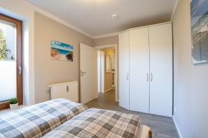 a bedroom with two beds and a closet at Premium Quartier Solymar Pelzerhaken in Neustadt in Holstein