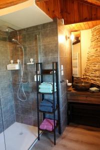 a bathroom with a shower and a rack with towels at Les Combres, gîte nature avec piscine in Malbosc