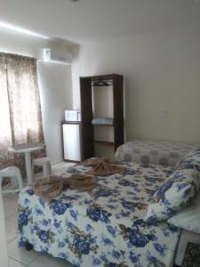 1 dormitorio con 1 cama con manta azul y blanca en Pousada Pingo d' Água, en Bombinhas