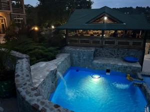 a swimming pool with a fountain in a yard at Fruškogorska Terasa in Novi Sad