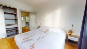 sypialnia z łóżkiem z białą narzutą w obiekcie Appartement Le Passage - Ostheim w mieście Ostheim