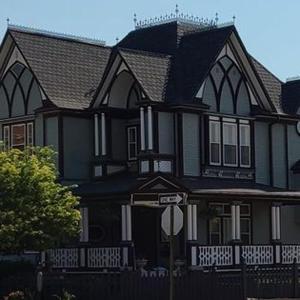 uma grande casa preta com uma placa de rua em frente em The Bissing House em Hays