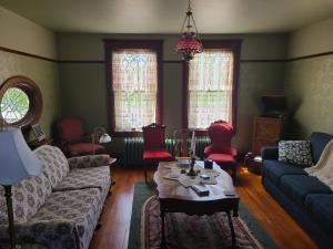 a living room with a couch and red chairs at The Bissing House in Hays