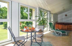 een veranda met een tafel en stoelen en een piano bij Cozy Home In Yvias With Indoor Swimming Pool in Yvias