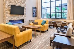 una sala de espera con sofás, mesas y TV en Staybridge Suites - Hillsboro North, an IHG Hotel en Hillsboro