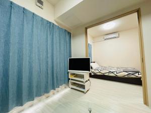 a bedroom with a bed and a tv and a mirror at 2-2札幌駅徒歩7分の好立地Service Apartment SAPPORO札幌ステーション綺麗な部屋 in Kita-rokujō
