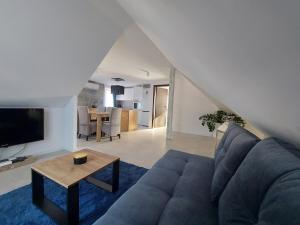 a living room with a blue couch and a table at Villa Fala in Dziwnówek