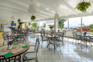 a dining room with tables and chairs and windows at Hotel Ossidiana Stromboli Center in Stromboli