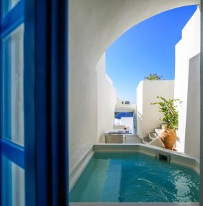 a swimming pool in the middle of a house at Pantelia Suites in Fira