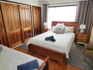 1 dormitorio con cama y ventana en A Holiday Home for Every Season, en Bateau Bay