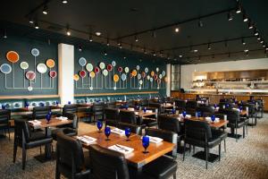 a dining room with tables and chairs and a wall with plates at Hotel Indigo - Madison Downtown by IHG in Madison