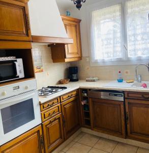 kuchnia z drewnianymi szafkami i kuchenką z piekarnikiem w obiekcie La Maryse de Cassis w Cassis +3 zdjęcia