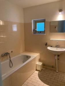 ein Badezimmer mit einer Badewanne und einem Waschbecken in der Unterkunft Karekiet 42 in Oudemirdum