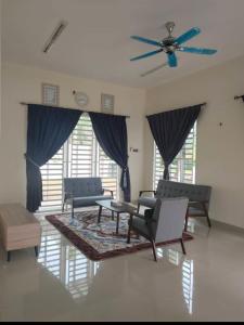 a living room with chairs and a ceiling fan at Pro-Qaseh Room Stay , Darulaman Lake Home in Jitra