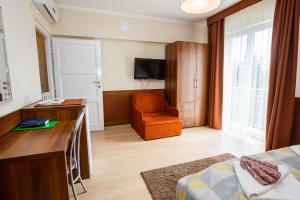 a room with a bed and a desk and a chair at Hotel Pávai in Hajdúszoboszló