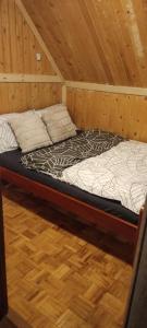 a bed in a room with a wooden floor at Sova in Kopaonik