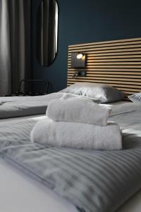 two beds with white towels on top of them at ARRIVEL Apartements Heimstetten in Kirchheim