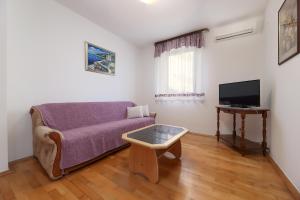 a living room with a couch and a tv at Jadranovo Dunja in Jadranovo