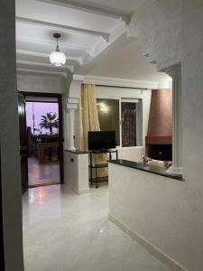 Villa a tamaris dar bouazza في الدار البيضاء: غرفة معيشة كبيرة مع موقد وتلفزيون