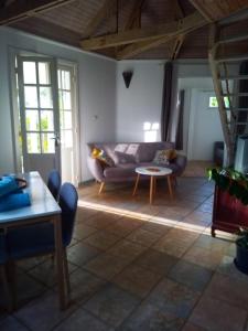 a living room with a couch and a table at Chalet PLEINSUD in Le Tampon