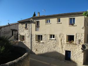 a stone building with windows and flowers in the windows at "Les Tournesols" in Saint-Martin-dʼArdèche