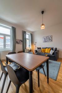 uma sala de estar com uma mesa de madeira e cadeiras em Dietrich Apartment I levestate em Viena