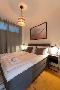 una camera da letto con un grande letto e un lampadario a braccio di Dietrich Apartment I levestate a Vienna