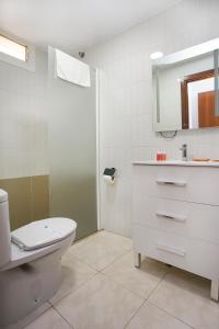a bathroom with a toilet and a sink and a mirror at L&G Apartamentos in Benidorm