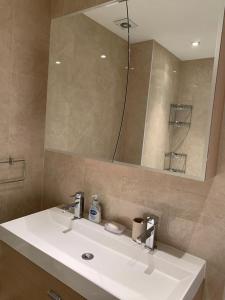a bathroom with a white sink and a mirror at Lovely 3 bedroom apartment in London