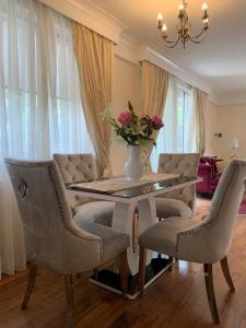 a dining room table with chairs and a vase with flowers at Lovely 3 bedroom apartment in London