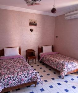 sypialnia z 2 łóżkami i stołem w obiekcie Marrakech Hôtel Résidence w Marakeszu