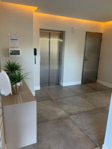 an empty lobby with two elevators in a building at Encanto dos Mares - Apartamento premium 4 in Camboriú +26 photos