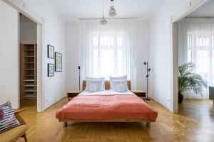 ein Schlafzimmer mit einem großen Bett mit einer roten Decke in der Unterkunft Captain Buda Apartment in Budapest