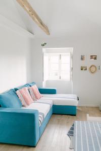 ein blaues Sofa in einem weißen Zimmer mit Fenster in der Unterkunft Casa Ver o Mar in São Mateus
