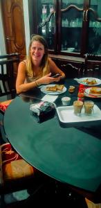 a woman sitting at a table with plates of food at GB25 inn in Trivandrum +79 photos