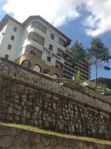 un edificio detrás de una pared de piedra delante de un edificio en Vila Siam - adults only holiday retreat, en Slănic-Moldova