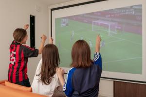 un gruppo di tre bambini che giocano a un videogioco su uno schermo di Fuji Gran Villa - TOKI - a Fujiyoshida