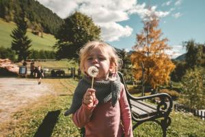 een klein meisje dat een donut op een stok eet bij Familienhotel Replerhof mit Kinderbetreuung in Prägraten