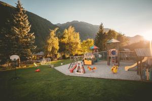 einen Park mit Spielplatz mit Rutsche und Spielgeräten in der Unterkunft Familienhotel Replerhof mit Kinderbetreuung in Prägraten