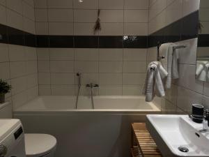 a bathroom with a tub and a toilet and a sink at Riga RiverPark - One-Bedroom Apartment Near Downtown in Rīga