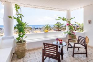 uma varanda com cadeiras e mesas e vista para a praia em Hotel Ossidiana Stromboli Center em Stromboli